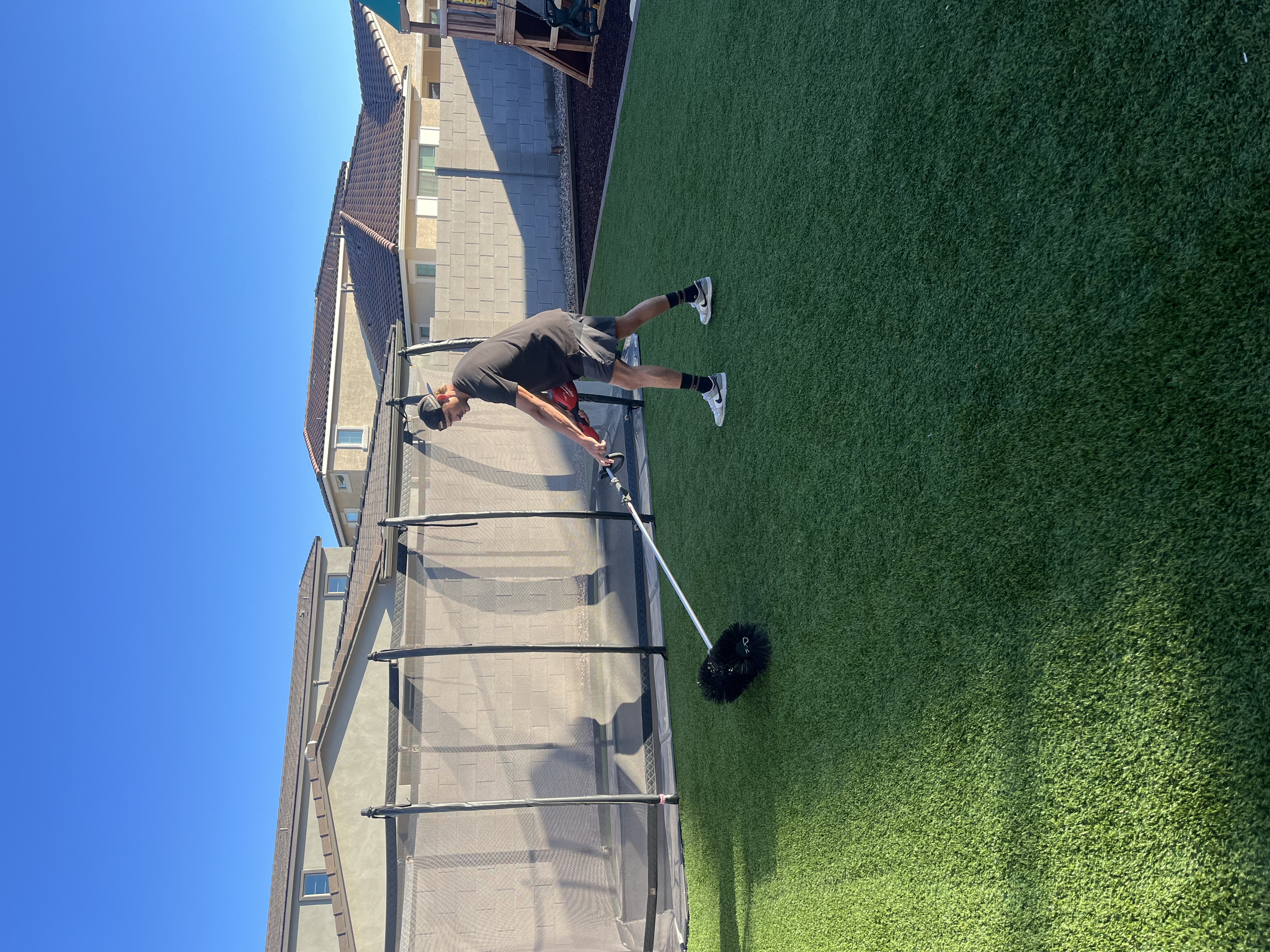 Turf cleaning professional working on artificial grass surface